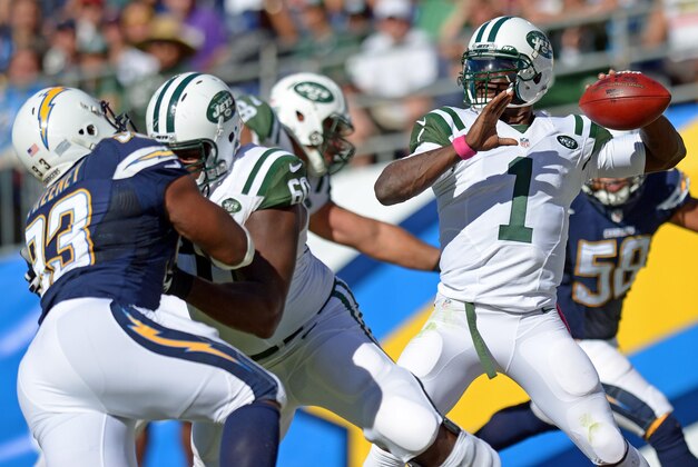 Oct 5, 2014; San Diego, CA, USA; New York Jets quarterback Michael Vick (1) drops back to pass during the third quarter as San Diego Chargers outside linebacker Dwight Freeney (93) rushes against Jets tackle D'Brickashaw Ferguson (60) at Qualcomm Stadium. Mandatory Credit: Jake Roth-USA TODAY Sports