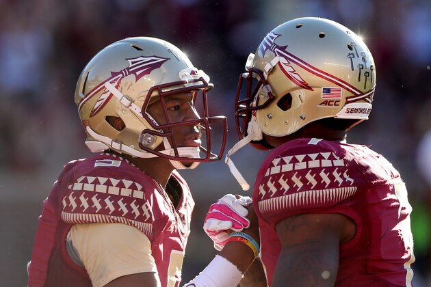 Florida State's Jameis Winston, left, celebrates with Mario Pender after Mario ran for a touchdown against the Wake Forest defense in an NCAA college football game, Saturday Oct. 4, 2014 in Tallahassee, Fla. Florida State won the game 43-3. (AP Photo/Steve Cannon)