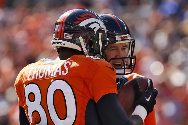 Denver Broncos quarterback Peyton Manning (18) hugs teammate Julius Thomas (80) after throwing his 500th career touchdown pass during the first half of an NFL football game against the Arizona Cardinals, Sunday, Oct. 5, 2014, in Denver. Thomas caught the pass. (AP Photo/Joe Mahoney)