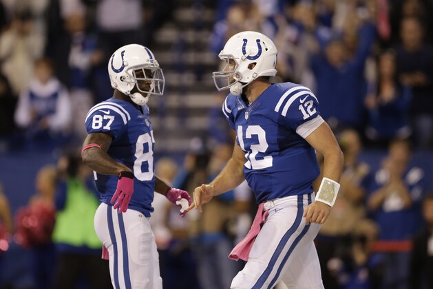 Indianapolis Colts quarterback Andrew Luck, right, celebrates with wide receiver Reggie Wayne after Luck scored a touchdown against the Baltimore Ravens during the second half of an NFL football game in Indianapolis, Sunday, Oct. 5, 2014. (AP Photo/Jeff Roberson)