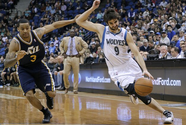 Minnesota Timberwolves guard Ricky Rubio (9), of Spain, tries to shake off Utah Jazz guard Trey Burke (3) on a drive during the fourth quarter of an NBA basketball game in Minneapolis, Wednesday, April 16, 2014. The Jazz won 136-130 in double overtime. (AP Photo/Ann Heisenfelt)