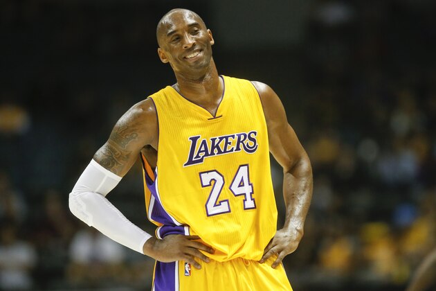 Los Angeles Lakers guard Kobe Bryant smiles after being called for traveling during the first half of a NBA preseason basketball game  Monday, Oct. 6, 2014, in San Diego. (AP Photo/Lenny Ignelzi