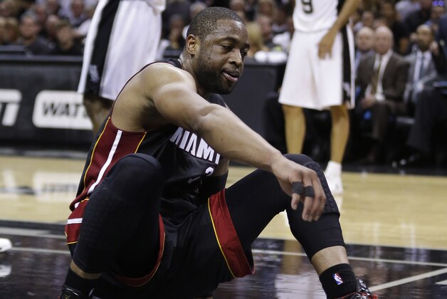 Miami Heat guard Dwyane Wade gets up after going down shoot against the San Antonio Spurs during the first half in Game 5 of the NBA basketball finals on Sunday, June 15, 2014, in San Antonio. (AP Photo/David J. Phillip)