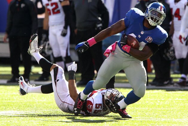 Oct 5, 2014; East Rutherford, NJ, USA; New York Giants running back Andre Williams (44) runs over Atlanta Falcons inside linebacker Paul Worrilow (55) during the second half at MetLife Stadium. The New York Giants defeated the Atlanta Falcons 30-20.Mandatory Credit: Noah K. Murray-USA TODAY Sports