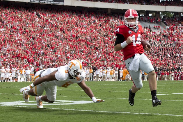 Georgia quarterback Hutson Mason (14) out runs Tennessee defensive end Derek Barnett (9) to the end zone for a touchdown in the first half of an NCAA college football game, Saturday, Sept. 27, 2014, in Athens, Ga. (AP Photo/John Bazemore)