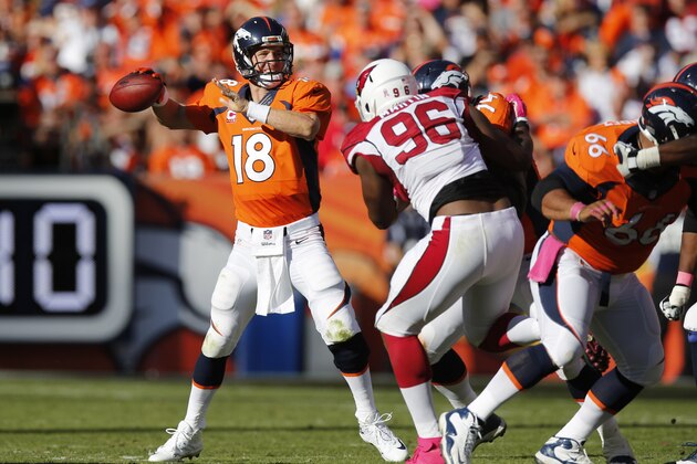 Denver Broncos quarterback Peyton Manning (18) throws as Arizona Cardinals defensive end Kareem Martin (96) pursues during the second half of an NFL football game, Sunday, Oct. 5, 2014, in Denver. (AP Photo/David Zalubowski)