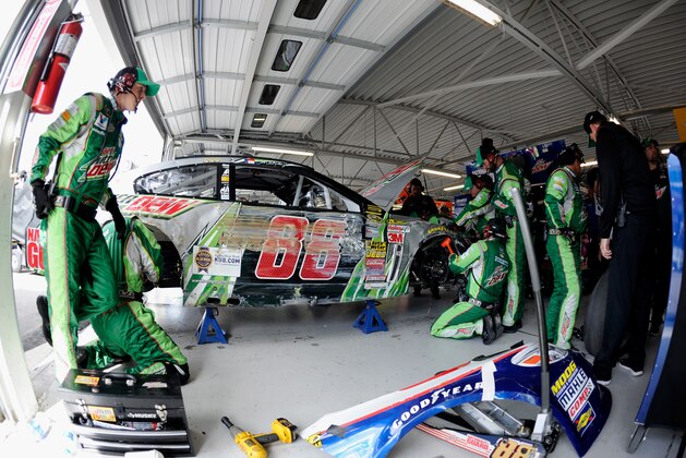 KANSAS CITY, KS - OCTOBER 05:  Crew members work on the car of Dale Earnhardt Jr., driver of the #88 Diet Mountain Dew Chevrolet, after crashing due to a tire failure during the NASCAR Sprint Cup Series Hollywood Casino 400 at Kansas Speedway on October 5, 2014 in Kansas City, Kansas.  (Photo by Jared C. Tilton/Getty Images)