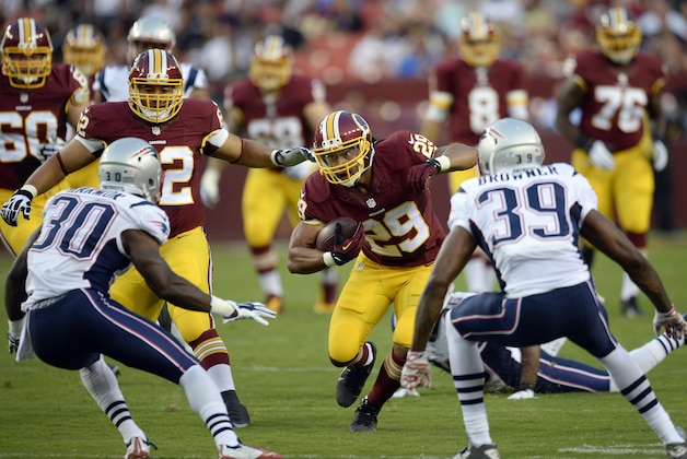 Aug 7, 2014; Landover, MD, USA; Washington Redskins running back Roy Helu (29) runs with the ball as New England Patriots strong safety Duron Harmon (30) and cornerback Brandon Browner (39) defend in the first quarter at FedEx Field. Mandatory Credit: Rafael Suanes-USA TODAY Sports