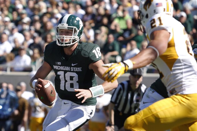 Michigan State quarterback Connor Cook (18) scrambles for a touchdown on a keeper against Wyoming's Mark Nzeocha during the first quarter of an NCAA college football game, Saturday, Sept. 27, 2014, in East Lansing, Mich. Michigan State won 56-14. (AP Photo/Al Goldis)