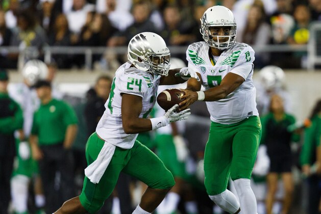Oregon quarterback Marcus Mariota (8) hands off to running back Thomas Tyner (24) during the second quarter of an NCAA college football game against South Dakota in Eugene, Ore., Saturday, Aug. 30, 2014. (AP Photo/Ryan Kang)