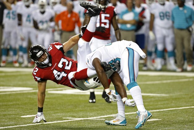 Atlanta Falcons fullback Patrick DiMarco (42) is tangled up by Miami Dolphins linebacker Jelani Jenkins (53) during the first half of an NFL preseason football game, Friday, Aug. 8, 2014, in Atlanta.  (AP Photo/John Bazemore)