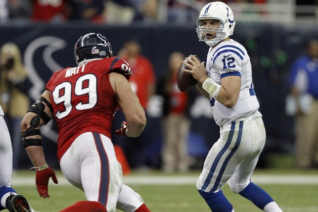 HOUSTON, TX - NOVEMBER 03: Andrew Luck #12 of the Indianapolis Colts drops back as J.J. Watt #99 of the Houston Texans applies pressure in the fourth quarter at Reliant Stadium on November 3, 2013 in Houston, Texas. (Photo by Bob Levey/Getty Images)