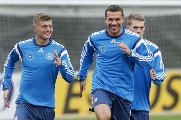Toni Kroos, left, and Lukas Podolski smile as they run during a training session of Germany's national soccer team in Frankfurt, Germany, Tuesday, Oct. 7, 2014. Germany will play against Poland in a group D qualifying match for the Euro 2016 in Warsaw next Saturday. (AP Photo/Michael Probst)