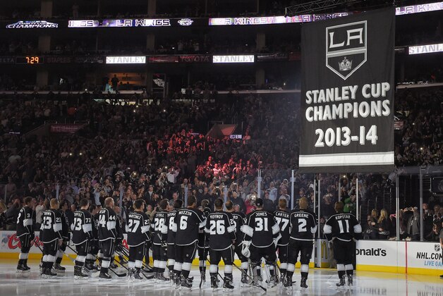 Members of the Los Angeles Kings help raise their second Stanley Cup championship banner prior to an NHL hockey game against the San Jose Sharks, Wednesday, Oct. 8, 2014, in Los Angeles. (AP Photo/Mark J. Terrill)