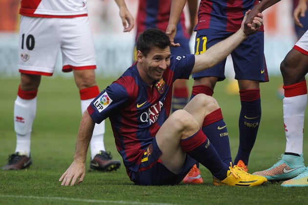 Barcelona's Lionel Messi smiles after a foul during a Spanish La Liga soccer match between Rayo Vallecano and FC Barcelona at the Vallecas stadium in Madrid, Spain, Saturday, Oct. 4, 2014. (AP Photo/Andres Kudacki)