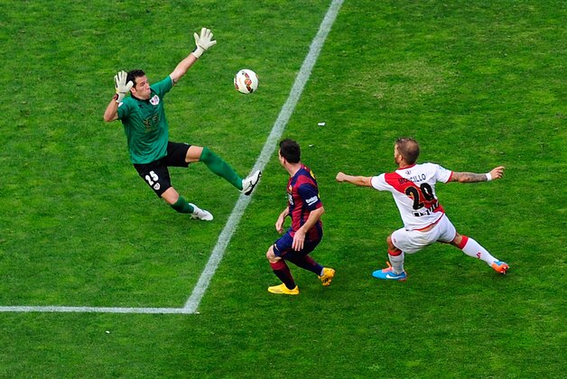 MADRID, SPAIN - OCTOBER 04:  Lionel Messi (L) of FC Barcelona beats Tono Rodriguez of Rayo Vallecano de Madrid to score his team's opening goal during the La Liga match between Rayo Vallecano de Madrid and FC Barcelona at Estadio Teresa Rivero on October 4, 2014 in Madrid, Spain.  (Photo by Denis Doyle/Getty Images)