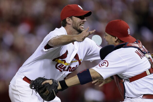 St. Louis Cardinals pitcher Adam Wainwright, left, celebrates with catcher Yadier Molina after the Cardinals defeated the Pittsburgh Pirates 6-1 to win Game 5 of a National League baseball division series, Wednesday, Oct. 9, 2013, in St. Louis. The Cardinals advanced to the NL championship series against the Los Angeles Dodgers. (AP Photo/Charlie Riedel)