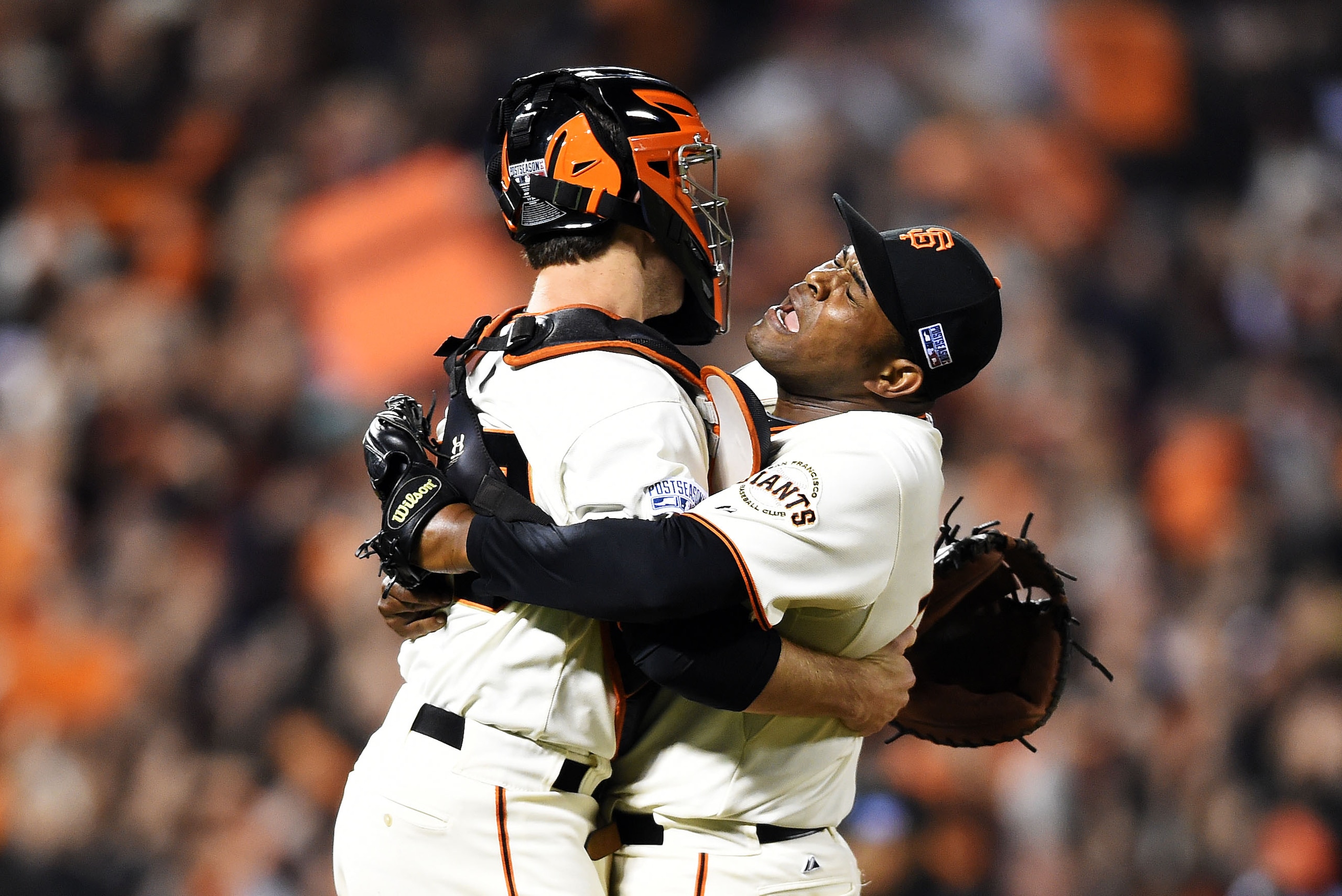 SAN FRANCISCO, CA - OCTOBER 07:  Santiago Casilla #46 and Buster Posey #28 of the San Francisco Giants celebrate after the final out of their 3 to 2 win over the Washington Nationals during Game Four of the National League Division Series at AT&T Park on October 7, 2014 in San Francisco, California.  (Photo by Thearon W. Henderson/Getty Images)