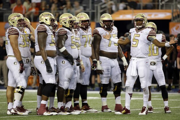 The offensive line stands by as Florida State quarterback Jameis Winston (5) looks to the sideline for the call in the final seconds of an NCAA college football game against Oklahoma State, Saturday, Aug. 30, 2014, in Arlington, Texas. FSU won 37-31. (AP Photo/Tony Gutierrez)