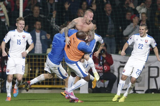 Slovakia's Miroslav Stoch, center top, celebrates with teammates after scoring his sides winning goal during their Group C Euro 2016 qualifying match between Slovakia and Spain in Zilina, Slovakia, Thursday, Oct. 9, 2014. (AP Photo/Petr David Josek)