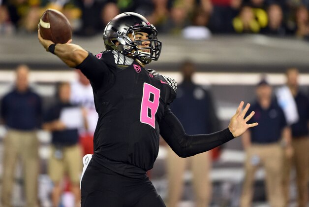 Oregon Ducks quarterback Marcus Mariota (8) passes the ball during the first quarter of the NCAA college  football game against Arizona at Autzen Stadium on Thursday, Oct. 2, 2014, in Eugene, Ore. Arizona won the game 31-24. (AP Photo/Steve Dykes)