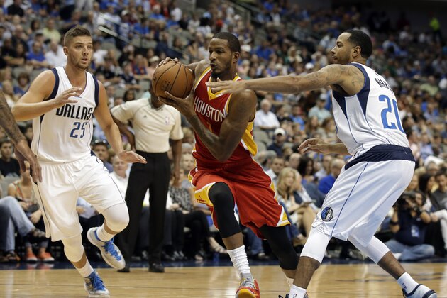 Dallas Mavericks' Chandler Parsons (25) and Devin Harris (20) defend as Houston Rockets guard Trevor Ariza, center, moves to the basket in the first half of a preseason NBA basketball game, Tuesday, Oct. 7, 2014, in Dallas. (AP Photo/Tony Gutierrez)