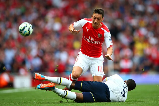 LONDON, ENGLAND - SEPTEMBER 27:  Mesut Oezil of Arsenal in action against Danny Rose of Spurs during the Barclays Premier League match between Arsenal and Tottenham Hotspur at Emirates Stadium on September 27, 2014 in London, England.  (Photo by Paul Gilham/Getty Images)