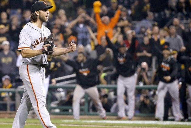 San Francisco Giants starting pitcher Madison Bumgarner starts to celebrate as teammates leave the dugout to join him after the last out against the Pittsburgh Pirates in the NL wild-card playoff baseball game Wednesday, Oct. 1, 2014, in Pittsburgh. The Giants won 8-0, advancing to a National League Division Series against the Washington Nationals. (AP Photo/Gene J. Puskar)