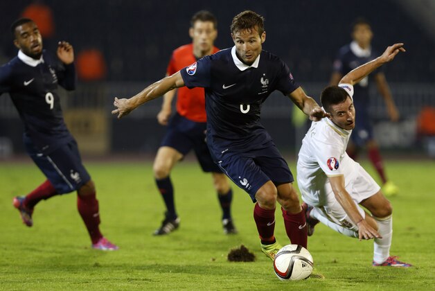 France's Yohan Cabaye, center, challenges with Serbia's Zoran Tosic during their international friendly soccer match in Belgrade, Serbia, Sunday, Sept. 7, 2014. (AP Photo/Darko Vojinovic)