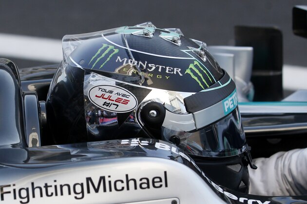Mercedes driver Nico Rosberg of Germany wearing his helmet with a sticker written in French 'Tous avec Jules' (Everybody with Jules) steers his car bearing a get well message that reads