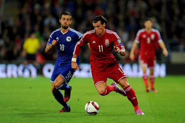 CARDIFF, WALES - OCTOBER 10:  Wales striker Gareth Bale (r) races past Bosnia player Miralem Pjanic during the EURO 2016 Qualifier match between Wales and Bosnia and Herzegovina at Cardiff City Stadium on October 10, 2014 in Cardiff, Wales.  (Photo by Stu Forster/Getty Images)