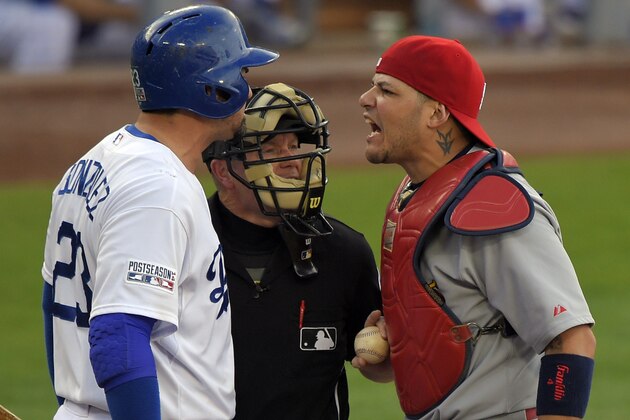 Los Angeles Dodgers' Adrian Gonzalez, left, and St. Louis Cardinals catcher Yadier Molina, right, argue in front of home plate umpire Jerry Meals after Dodgers' Yasiel Puig was hit by a pitch in the third inning of Game 1 of baseball's NL Division Series in Los Angeles, Friday, Oct. 3, 2014. (AP Photo/Mark J. Terrill)