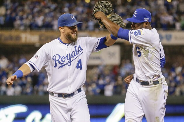 Kansas City Royals center fielder Lorenzo Cain (6) and left fielder Alex Gordon (4) celebrate after Cain made a leaping catch for a ball hit by Los Angeles Angels' Howie Kendrick during the fifth inning of Game 3 of baseball's AL Division Series in Kansas City, Mo., Sunday, Oct. 5, 2014. (AP Photo/Charlie Riedel)
