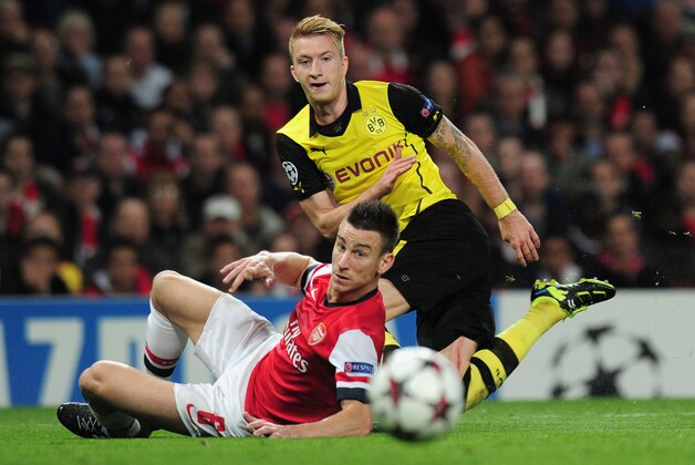 LONDON, ENGLAND - OCTOBER 22: Marco Reus of Borussia Dortmund and Laurent Koscielny of Arsenal in action during the UEFA Champions League Group F match between Arsenal and  Borussia Dortmund at Emirates Stadium on October 22, 2013 in London, England.  (Photo by Shaun Botterill/Getty Images)