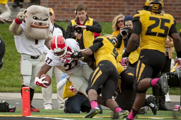 Georgia running back Nick Chubb, left, scores a touchdown as he gets past Missouri's Braylon Webb, center, and Donavin Newsom, right, during the fourth quarter of an NCAA college football game Saturday, Oct. 11, 2014, in Columbia, Mo. Georgia won the game 34-0. (AP Photo/L.G. Patterson)