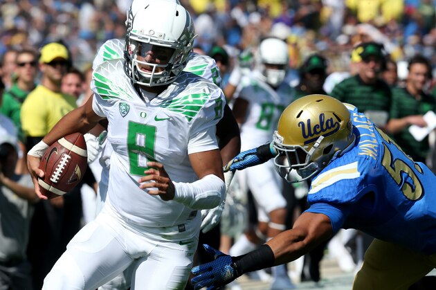 PASADENA, CA - OCTOBER 11:  Quarterback Marcus Mariota #8 of the Oregon Ducks carries on a 13 yard touchdown run in the first quarter against linebacker Aaron Wallace #51 of the UCLA Bruins at the Rose Bowl on October 11, 2014 in Pasadena, California.  (Photo by Stephen Dunn/Getty Images)