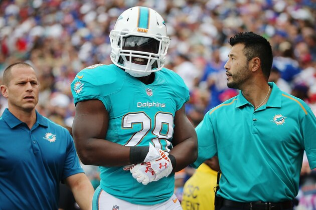 ORCHARD PARK, NY - SEPTEMBER 14:   Knowshon Moreno #28 of the Miami Dolphins is walked off the field after being injured against the Buffalo Bills  during the first half at Ralph Wilson Stadium on September 14, 2014 in Orchard Park, New York.  (Photo by Tom Szczerbowski/Getty Images)