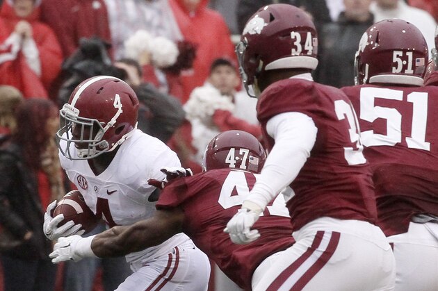 Alabama running back T.J. Yeldon (4) gets past Arkansas defenders linebackers Martrell Spaight (47), Braylon Mitchell (34) and Brooks Ellis (51) in the first half of an NCAA college football game in Fayetteville, Ark., Saturday, Oct. 11, 2014. (AP Photo/Danny Johnston)
