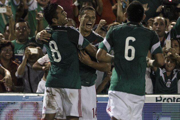 Mexico's Javier Hernandez, center, celebrates with Marco Fabian, left and Miguel Herrera after scoring against Honduras during a friendly soccer match, in Tuxtla Gutierrez, Thursday, Oct. 9, 2014. (AP Photo/Christian Palma)