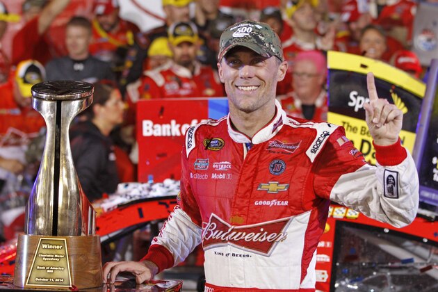 Kevin Harvick poses with the trophy in Victory Lane after winning the NASCAR Sprint Cup series Bank of America 500 auto race at Charlotte Motor Speedway in Concord, N.C., Saturday, Oct. 11, 2014. (AP Photo/Terry Renna)
