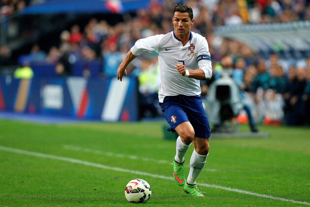 Portugal's Cristiano Ronaldo runs with the ball, during his international friendly soccer match against France, at the Stade de France, in Saint Denis, north of Paris, France, Saturday, Oct. 11, 2014. (AP Photo/Thibault Camus)
