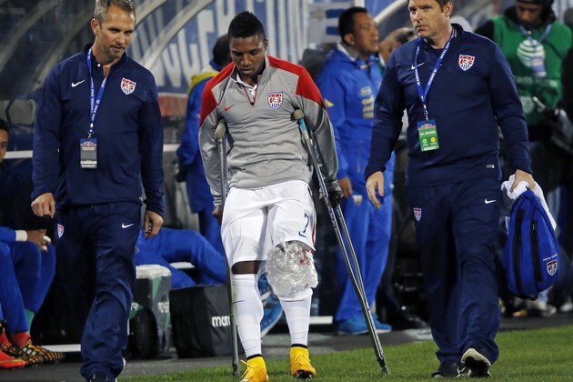 United States' Joe Gyau (7) is accompanied by trainers as he walks off the field on crutches after injuring his knee during the firs thalf of an exhibition soccer match against Ecuador in East Hartford, Conn., Friday, Oct. 10, 2014. Gyau sprained his left knee, according to US Soccer. (AP Photo/Elise Amendola)