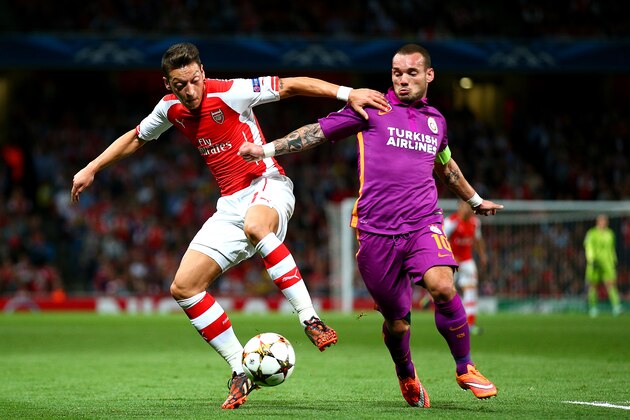LONDON, ENGLAND - OCTOBER 01:  Mesut Oezil of Arsenal battles for tha ball with Wesley Sneijder of Galatasaray AS during the UEFA Champions League group D match between Arsenal FC and Galatasaray AS at Emirates Stadium on October 1, 2014 in London, United Kingdom.  (Photo by Paul Gilham/Getty Images)