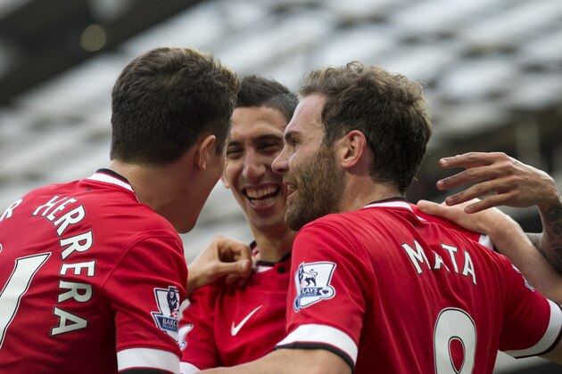Manchester United's Juan Mata, right, celebrates with teammates Angel Di Maria, centre, and Abder Herrera after scoring against Queens Park Rangers during their English Premier League soccer match at Old Trafford Stadium, Manchester, England, Sunday Sept. 14, 2014. (AP Photo/Jon Super)