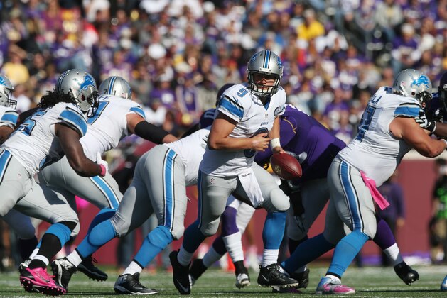 Detroit Lions quarterback Matthew Stafford (9) prepares to hand off to running back Joique Bell during the second half of an NFL football game against the Minnesota Vikings, Sunday, Oct. 12, 2014, in Minneapolis. (AP Photo/Jim Mone)