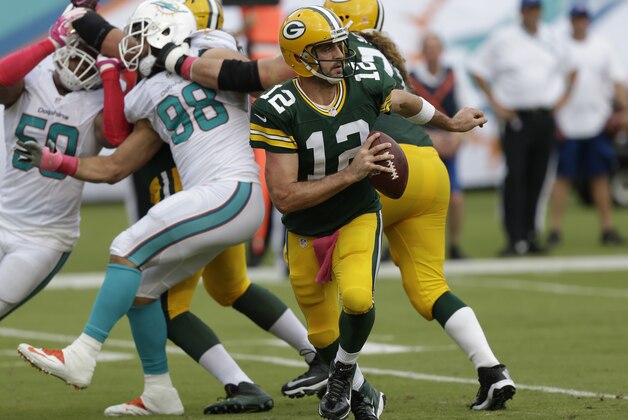 Green Bay Packers quarterback Aaron Rodgers (12) looks to pass during the first half of an NFL football game against the Miami Dolphins, Sunday, Oct. 12, 2014, in Miami Gardens, Fla. (AP Photo/Wilfredo Lee)