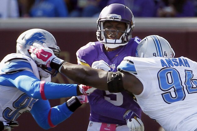 Minnesota Vikings quarterback Teddy Bridgewater is rushed by Detroit Lions defensive end George Johnson (93) left, and defensive end Ezekiel Ansah (94) after releasing the ball during the second half of an NFL football game Sunday, Oct. 12, 2014, in Minneapolis. (AP Photo/Ann Heisenfelt)