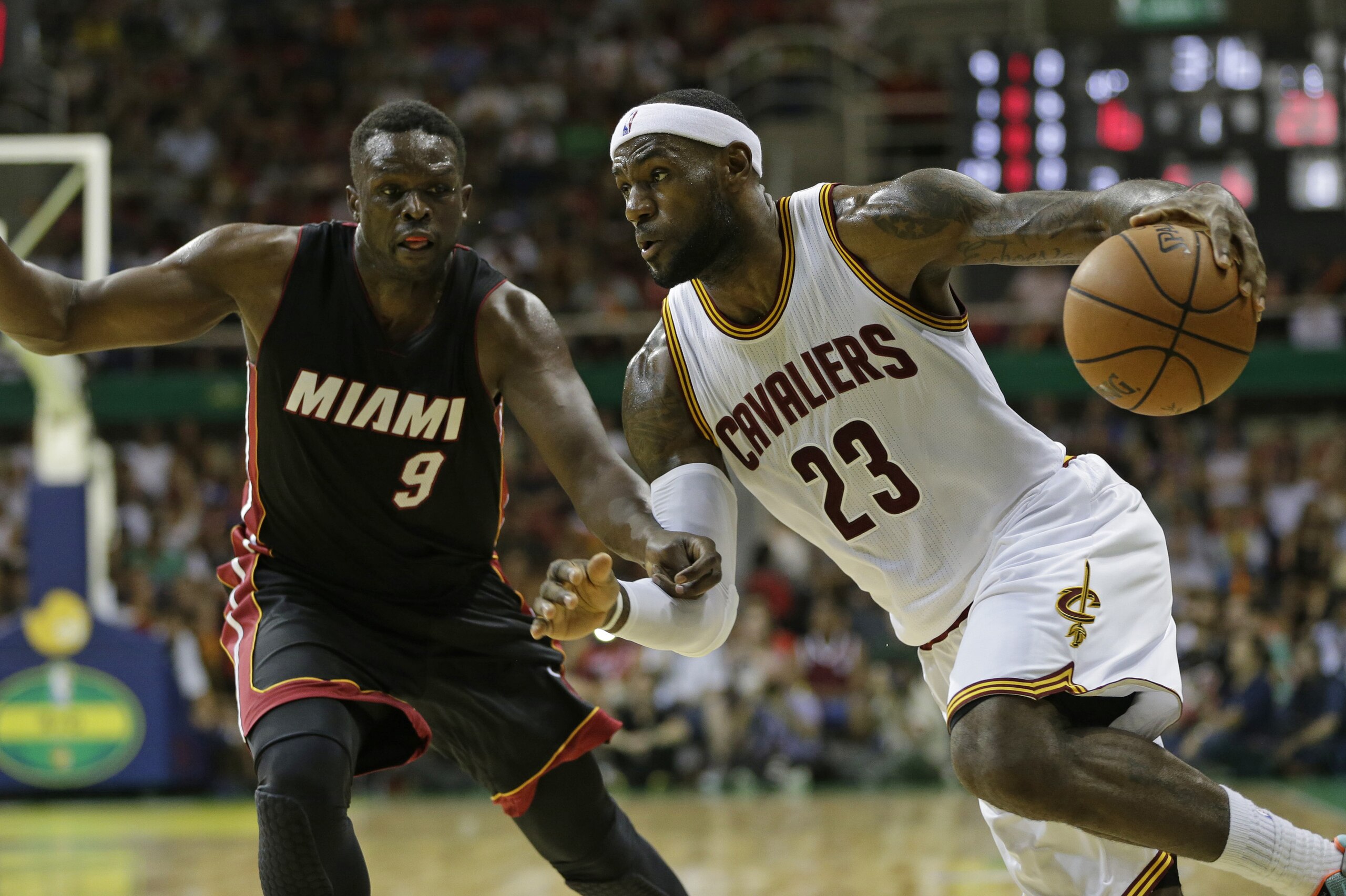 Cleveland Cavaliers' LeBron James, right, drives past Miami Heat's Luol Deng during a NBA preseason basketball game as part of the NBA Global Games, in Rio de Janeiro, Brazil, Saturday, Oct. 11, 2014. (AP Photo/Felipe Dana)
