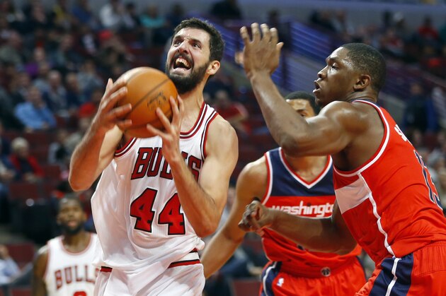 Chicago Bulls forward Nikola Mirotic (44) goes past Washington Wizards center Kevin Seraphin (13) during the second half of a pre-season NBA basketball game in Chicago, on Monday Oct. 6, 2014. The Wizards won the game 85-81. (AP Photo/Jeff Haynes)