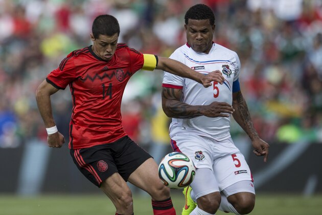 Mexico's Javier Hernandez, left, fights for the ball with Panama's Roman Torres during a friendly soccer match in Queretaro, Sunday, Oct. 12, 2014. (AP Photo/Christian Palma)